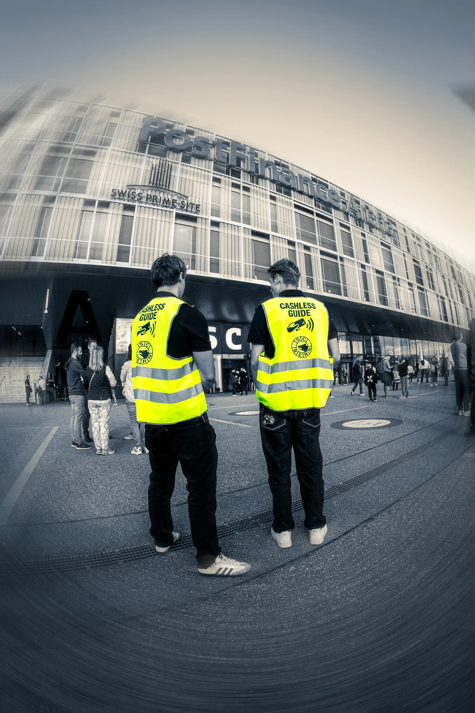 Zwei Mitarbeitende in Leuchtwesten vor dem Stadion