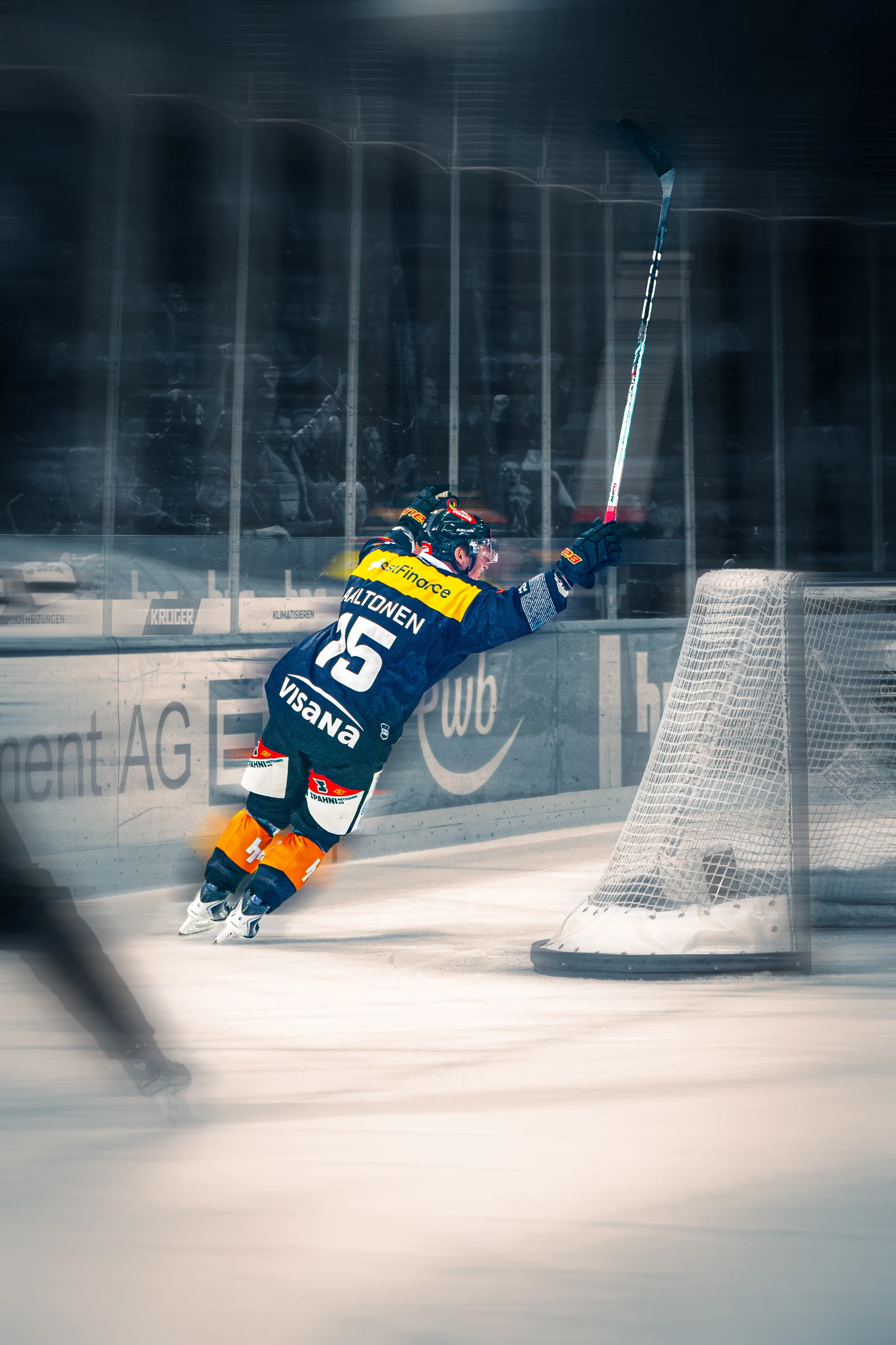 Eishockeyspieler in Bewegung an der Bande, mit verwischtem Vordergrund