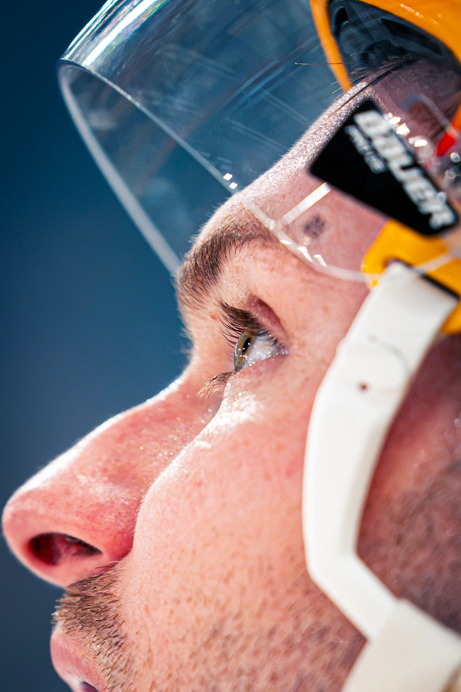 Detailaufnahme des Gesichts eines Eishockeyspielers hinter dem Helmvisier