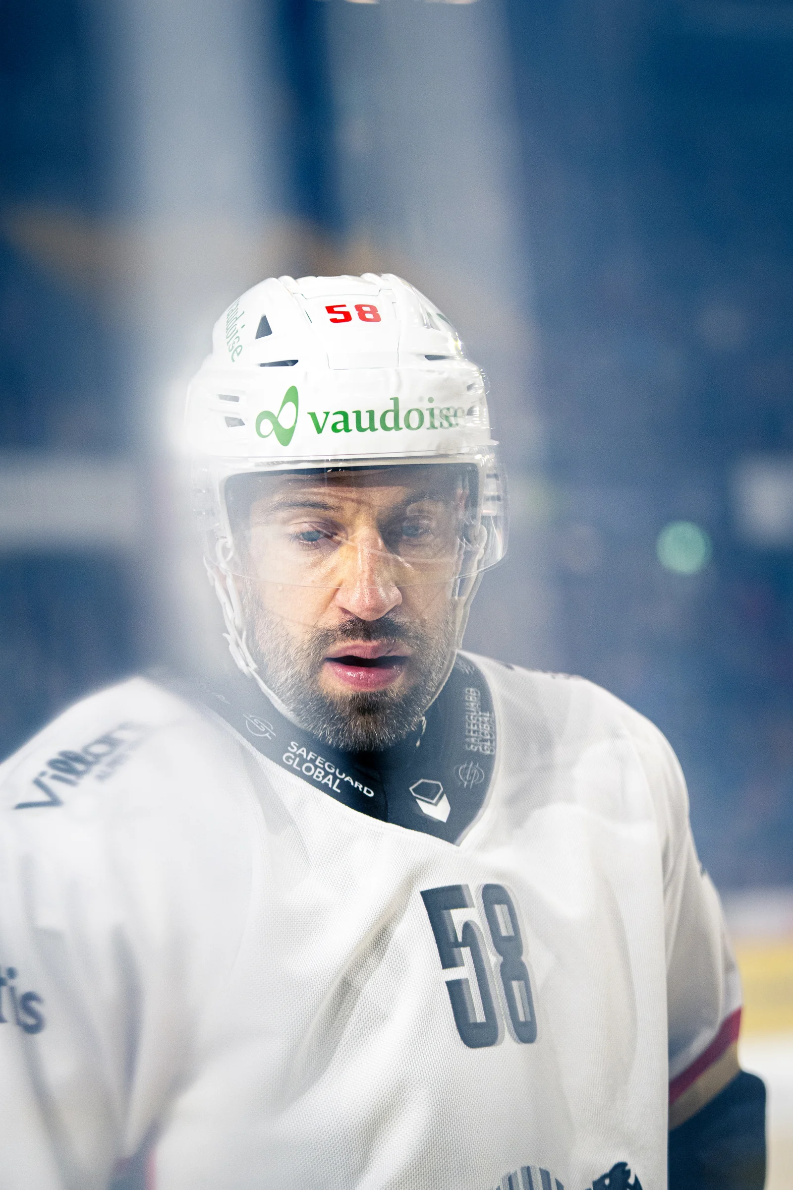 Nahaufnahme eines Lausanne-Spielers mit weissem Helm und der Nummer 58 hinter der Scheibe