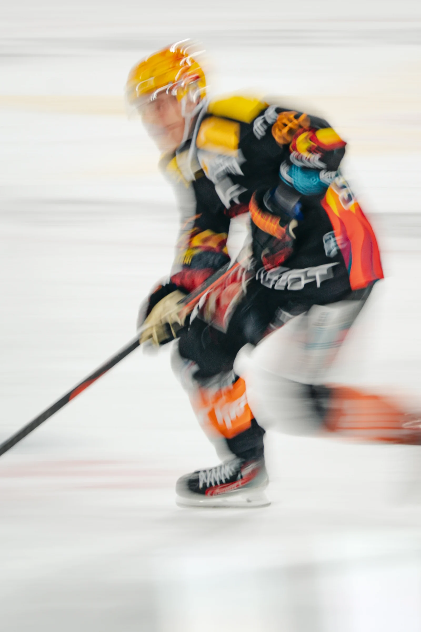 Eishockeyspieler mit gelbem Helm in einer Aufnahme mit Bewegungsunschärfe