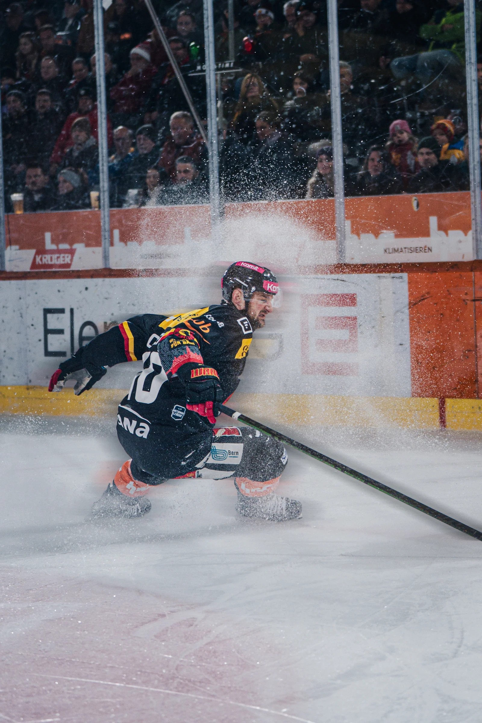 SC-Bern-Spieler in der Kurve mit aufspritzendem Eis